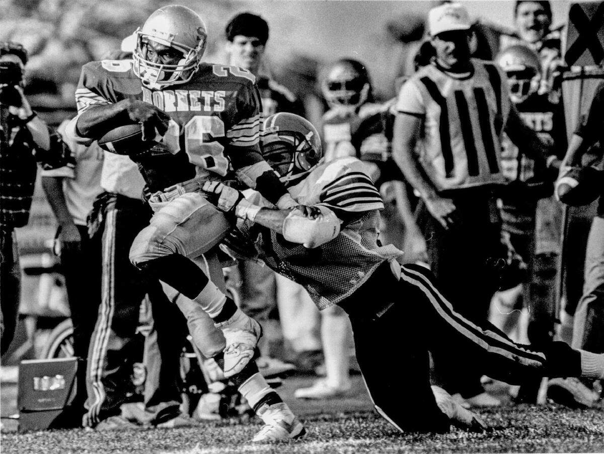 Sacramento State running back Donald Hair (26) carries the ball as a Cal State Northridge defender attempts to bring him down in 1986.