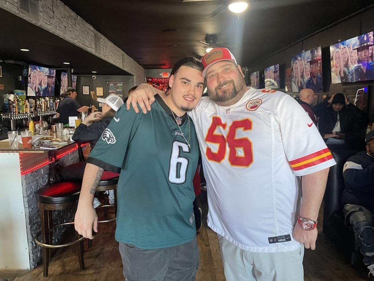 Field House owner Matthew Wagner and his son James pose in their favorite teams’ jerseys during the Super Bowl LIX watch party on Sunday.