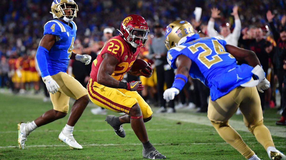 USC running back Darwin Barlow (22) evades UCLA defensive back Jaylin Davies (24) for a touchdown at the Rose Bowl in Pasadena in 2022.
