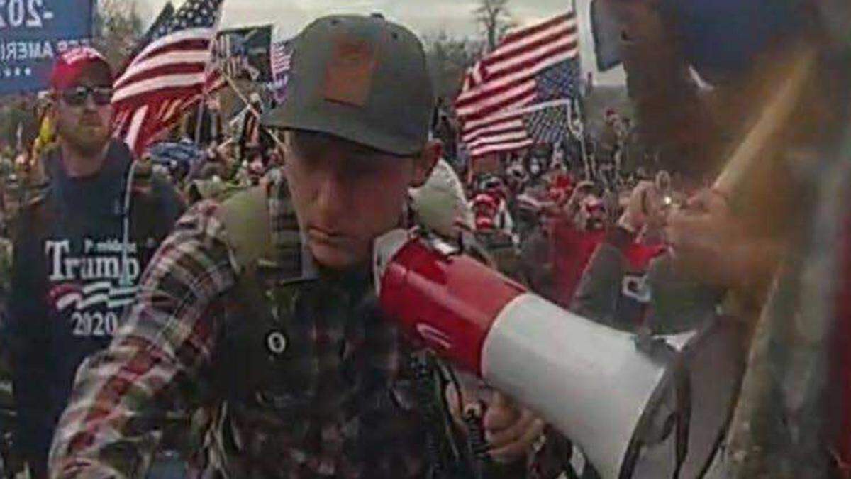 Sean Michael McHugh, 34, of Auburn is seen holding a megaphone in this video image provided by prosecutors, who alleges that McHugh sprayed U.S. Capitol Police officers with a chemical substance and assaulted them with a metal sign during the Jan. 6, 2021, insurrection at the U.S. Capitol.