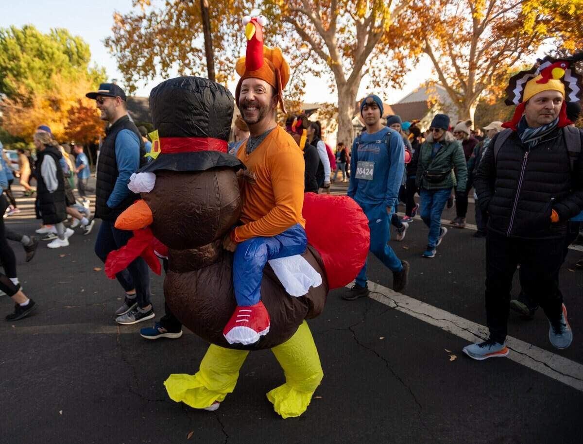 Jason Gritti of Sacramento wearing a turkey costumes walks down J Street during the Run to Feed the Hungry in Sacramento on Thursday.