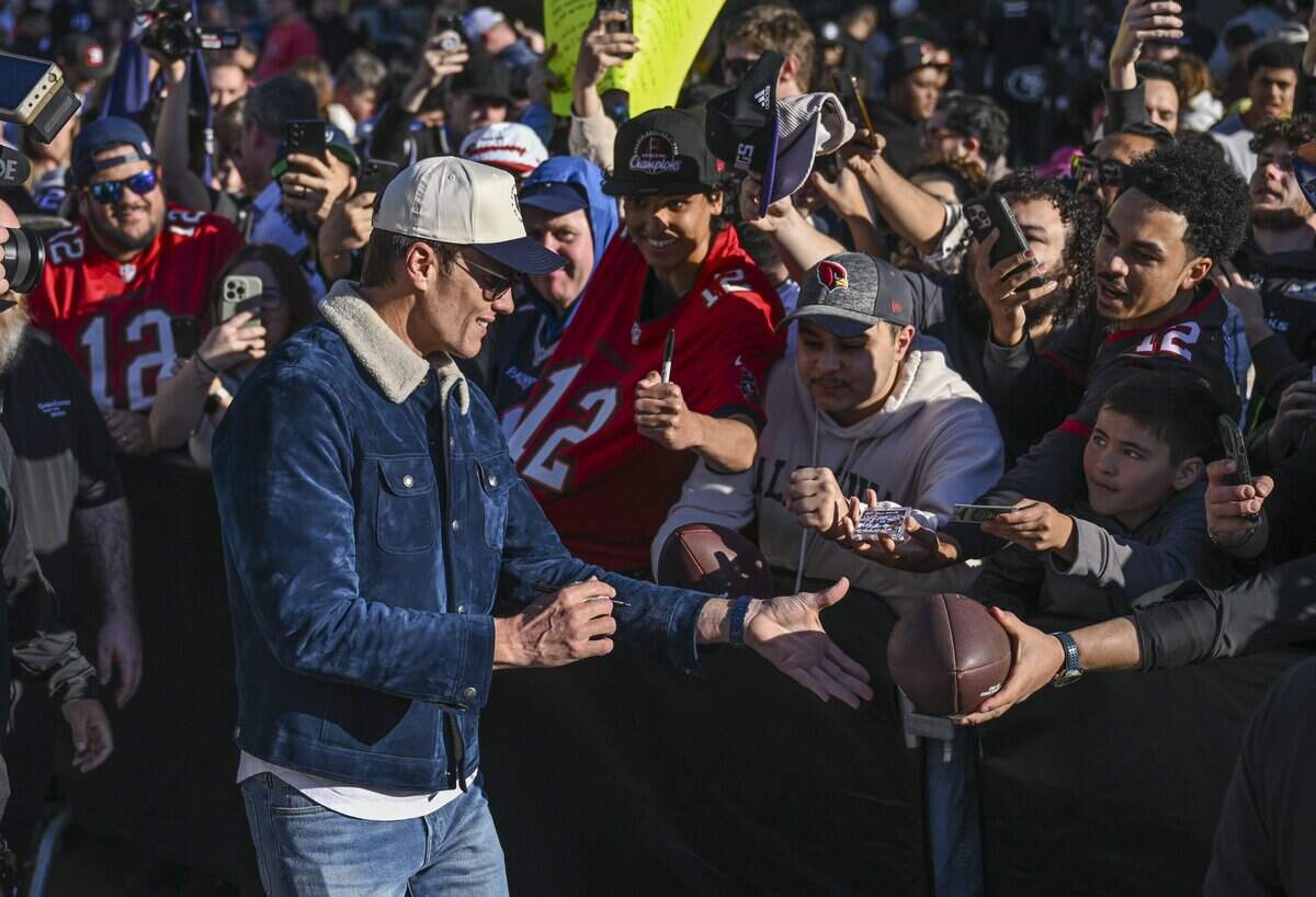 Legendary former NFL quarterback Tom Brady signs autographs for fans during a rally for Brady’s newly opened CardVault store in Downtown Commons in Sacramento on Thursday.