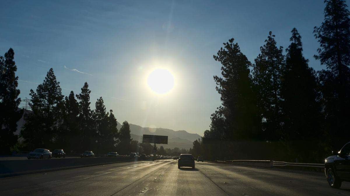 A strong morning sun rises over the Ventura Freeway State Route 134 in Burbank, Calif. on Friday, July 6, 2018. Forecasters say temperatures will soar into triple digits throughout almost all of Southern California as a brief but intense heat wave broils the region.