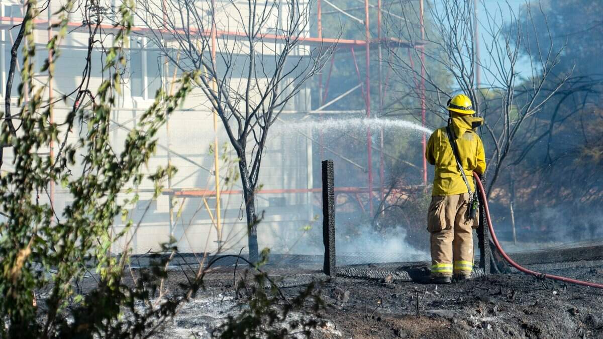 Firefighters work to save a house on U Street near 28th Street in Rio Linda during a vegetation fire on Monday, Sept. 27, 2021.