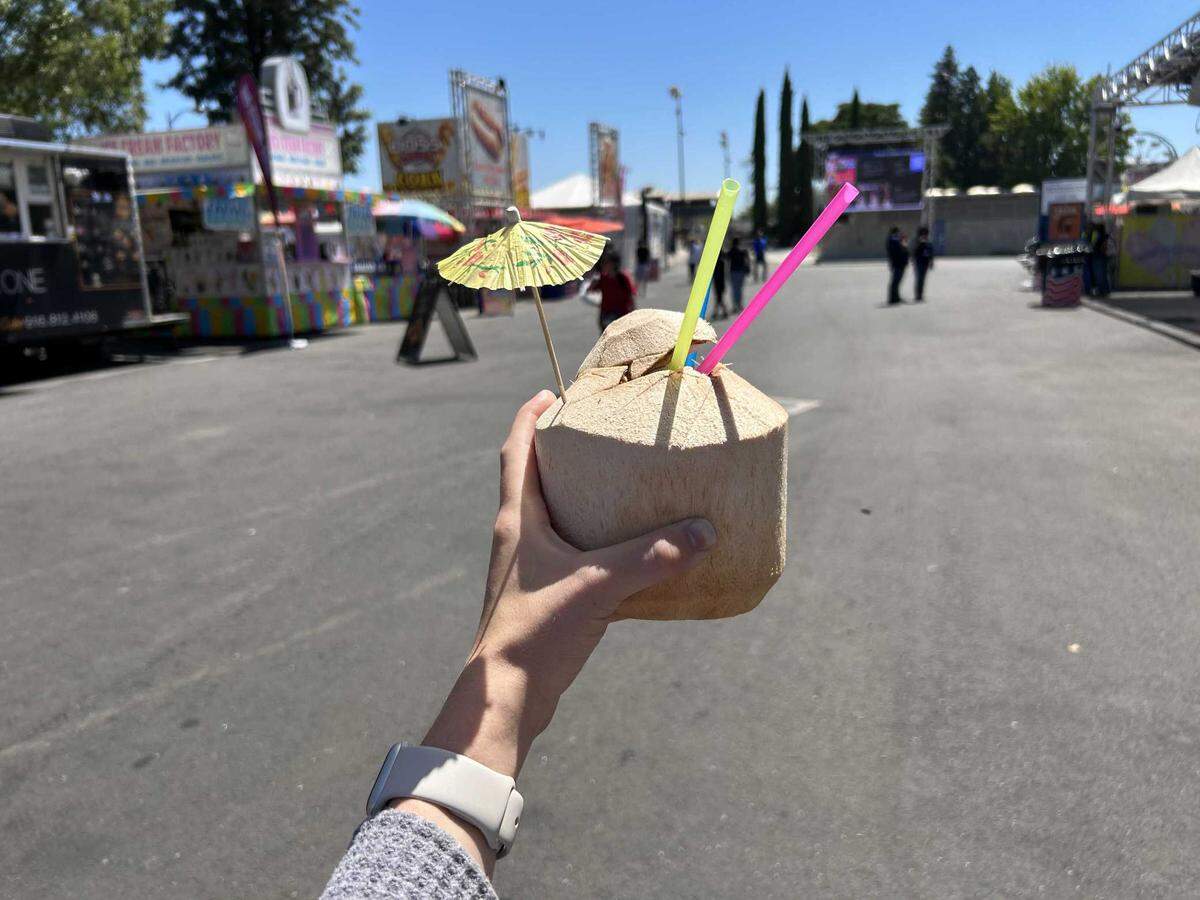 A raw coconut from Machete Fresh Coconuts served as a refreshing drink during extreme hot weather at the California State Fair.