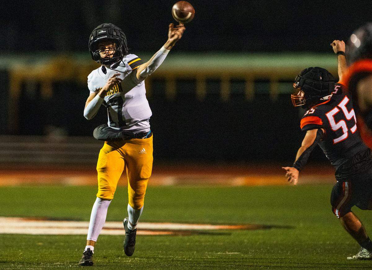 Hughson Huskies quarterback Hudson Baldwin (17) throws a pass as the Roseville Tigers’ Collin McClain (55) brings pressure in a CIF Sac-Joaquin Section Division IV semifinal in Roseville on Friday, Nov. 21, 2025.