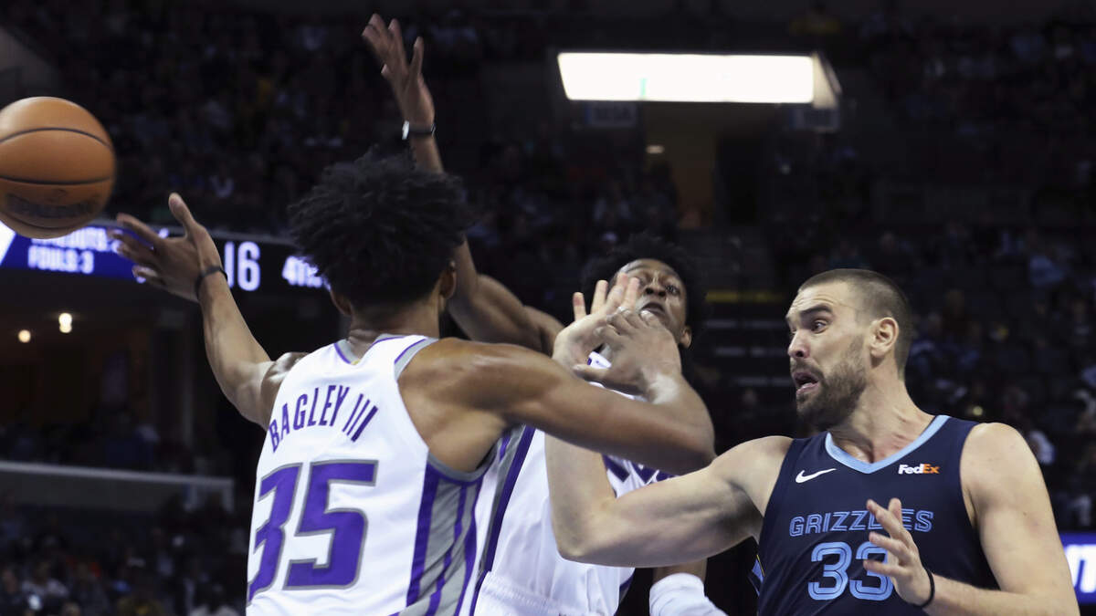 Memphis Grizzlies center Marc Gasol, right, is defended by Kings forward Marvin Bagley lll and guard De’Aaron Fox on Friday in Memphis, Tenn. Gasol became the Grizzlies’ all-time rebounding leader in a 112-104 win over the Kings.