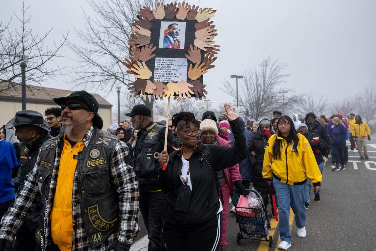 Lisa Morris carries a handmade sign as she marches in the Martin Luther King Jr. “Walk With Me” event at Sacramento City College on Monday. She said the sign represents how people come together for the march. “Because of the way things are going today with the current state of government, I think we need more unity.”