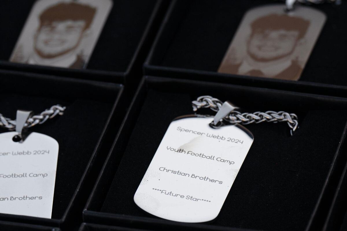 Necklaces with Spencer Webb’s image on one side and words describing the football camp on the reverse side are displayed at the end of the Spencer Webb Youth Football and Cheer Camp on Wednesday at Christian Brothers High School.