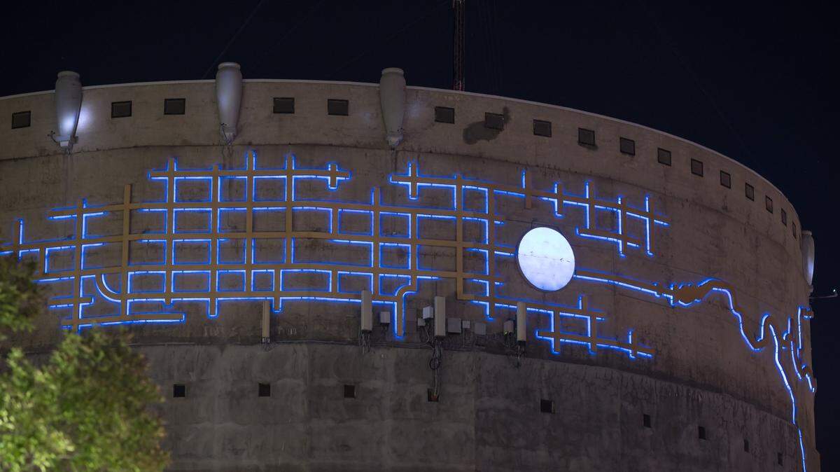 Michael Bishop’s art, a representation of the circular water tower surrounded by the Sacramento street grid and winding river and delta, lights up blue at night on the side of the immense concrete water tower behind the Alhambra Safeway, known as the Alhambra Reservoir.