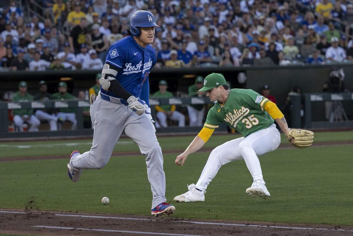 Los Angeles Dodgers two-way player Shohei Ohtani runs to first base as Athletics pitcher J.T. Ginn picks up the ball during a game Wednesday at Sutter Health Park in West Sacramento.