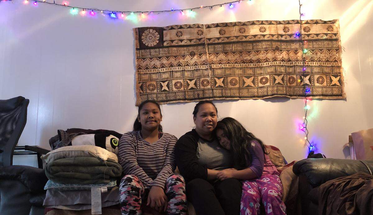 Charles Joseph’s family – wife Shelly Clements, center, and daughters Hope, 12, and Carly, 7 – sit in their south Sacramento apartment.
