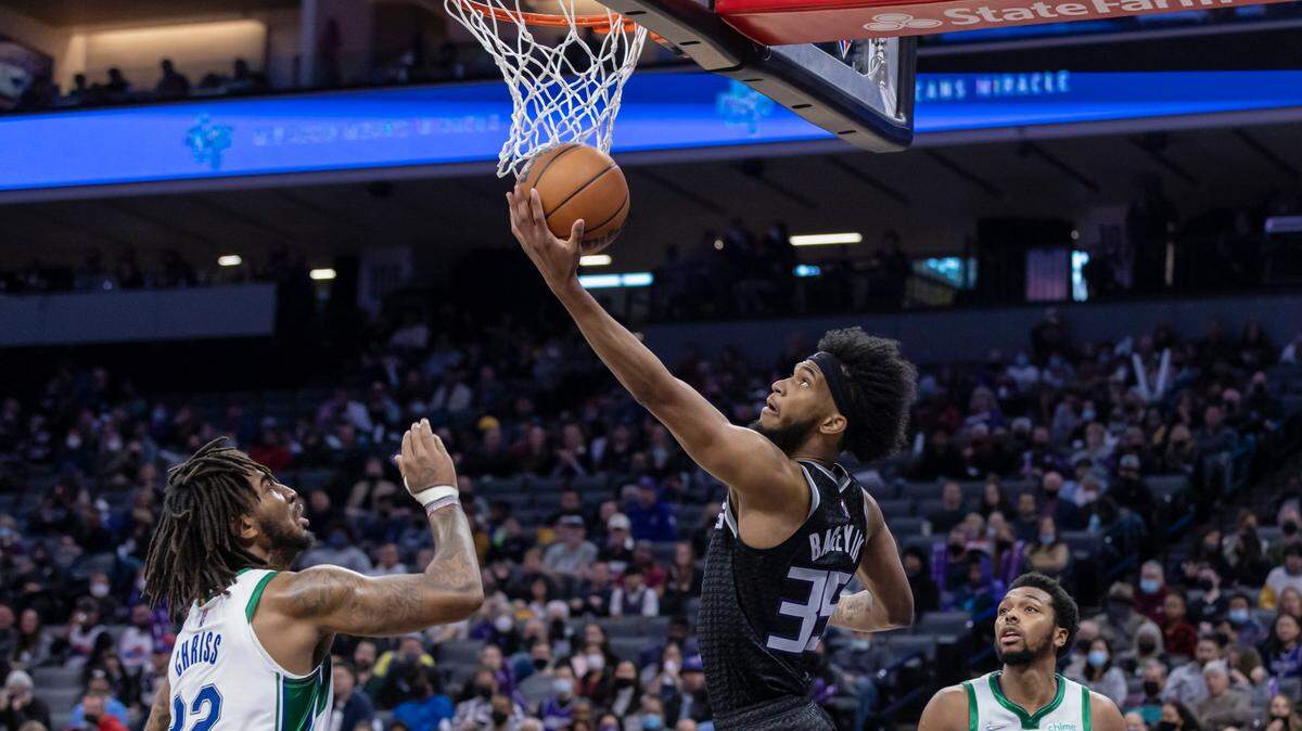 Sacramento Kings forward Marvin Bagley III (35) makes a reverse layup past Dallas Mavericks forward Marquese Chriss (32) and forward Sterling Brown (0) during the second quarter on Friday, Dec. 31, 2021 during an NBA basketball game at the Golden 1 Center in Sacramento. Bagley III had 15 points and five rebounds. The Mavericks won 112-96.