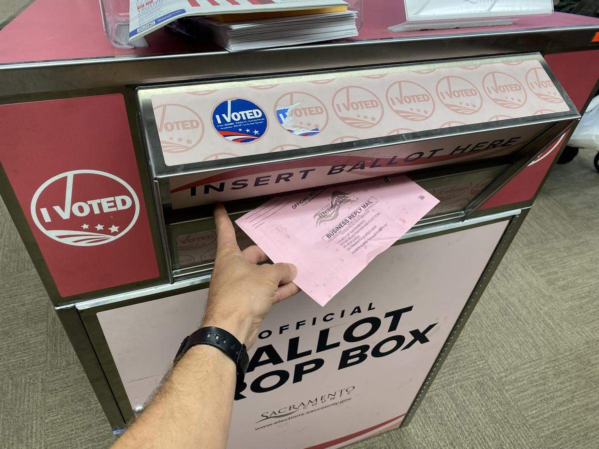 Sacramento Bee reporter William Melhado drops his Proposition 50 ballot off at McKinley Library in Sacramento