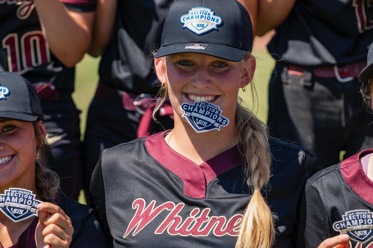 The Whitney Wildcats’ Tylie Kitchen celebrates with the section championship banner on May 24 after her team won the CIF Sac-Joaquin Section Division II championship softball game against the Rocklin Thunder 2-0 at Sacramento State.