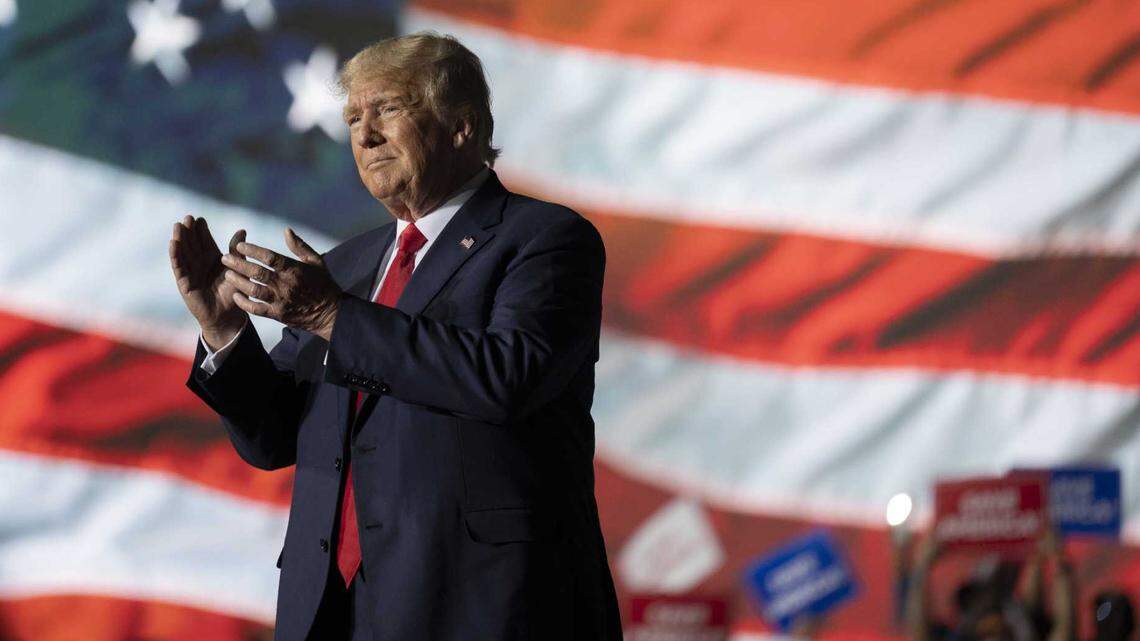 Former President Donald Trump applauds Saturday while attending a rally at the Minden Tahoe Airport in Minden, Nev.