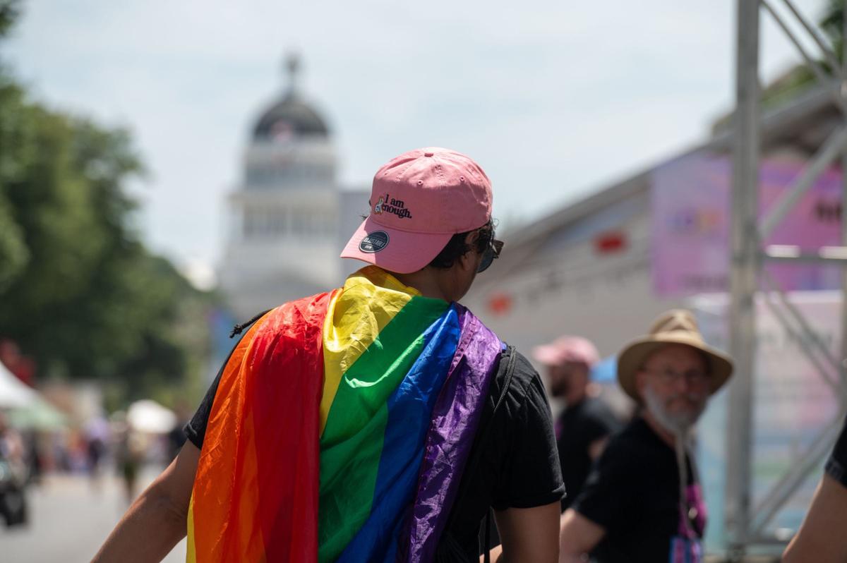A person wearing a gay pride flag cape and a hat reading “I am Kenough” attends the 33rd annual Sacramento Pride festival on Saturday, June 8, 2024.