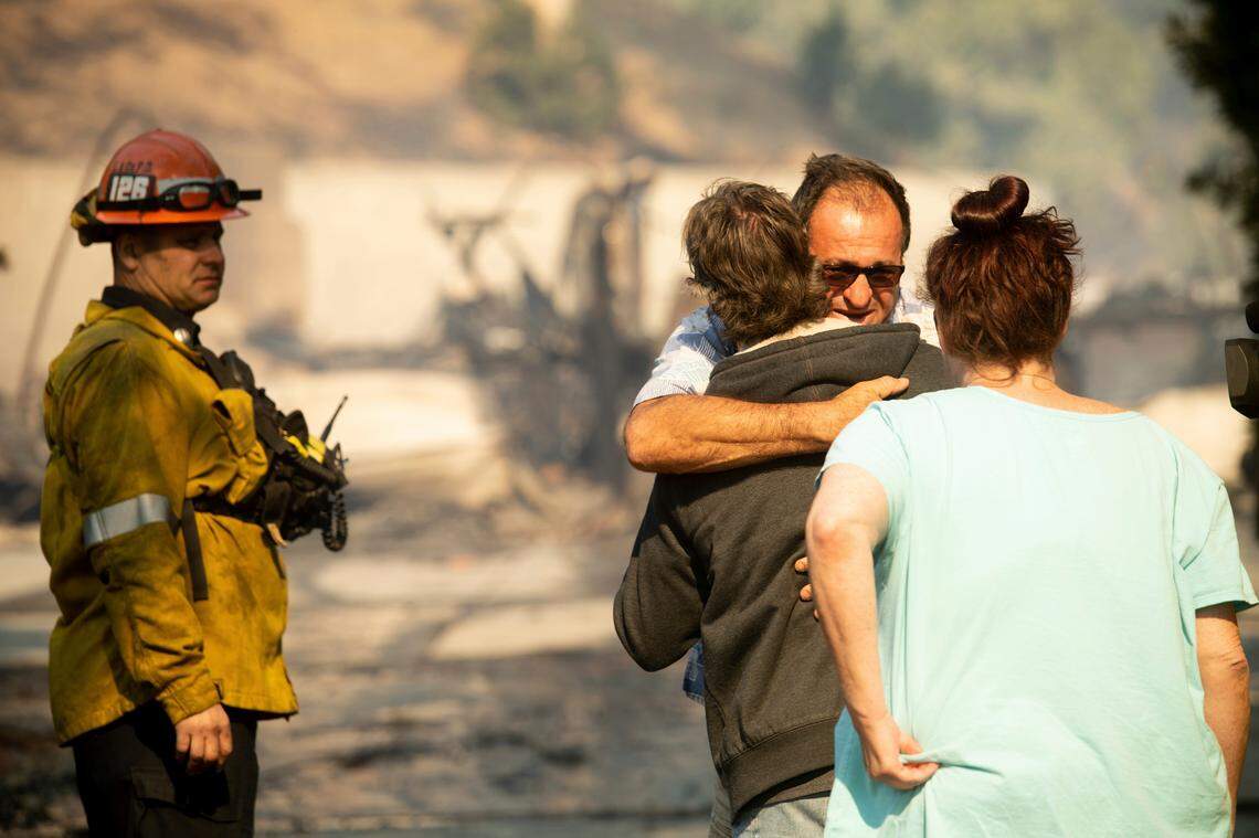 Eyed Jarjour comforts a neighbor who lost his Jolette Ave. home to the Saddleridge Fire on Friday, Oct. 11, 2019, in Granada Hills, Calif. (AP Photo/Noah Berger)