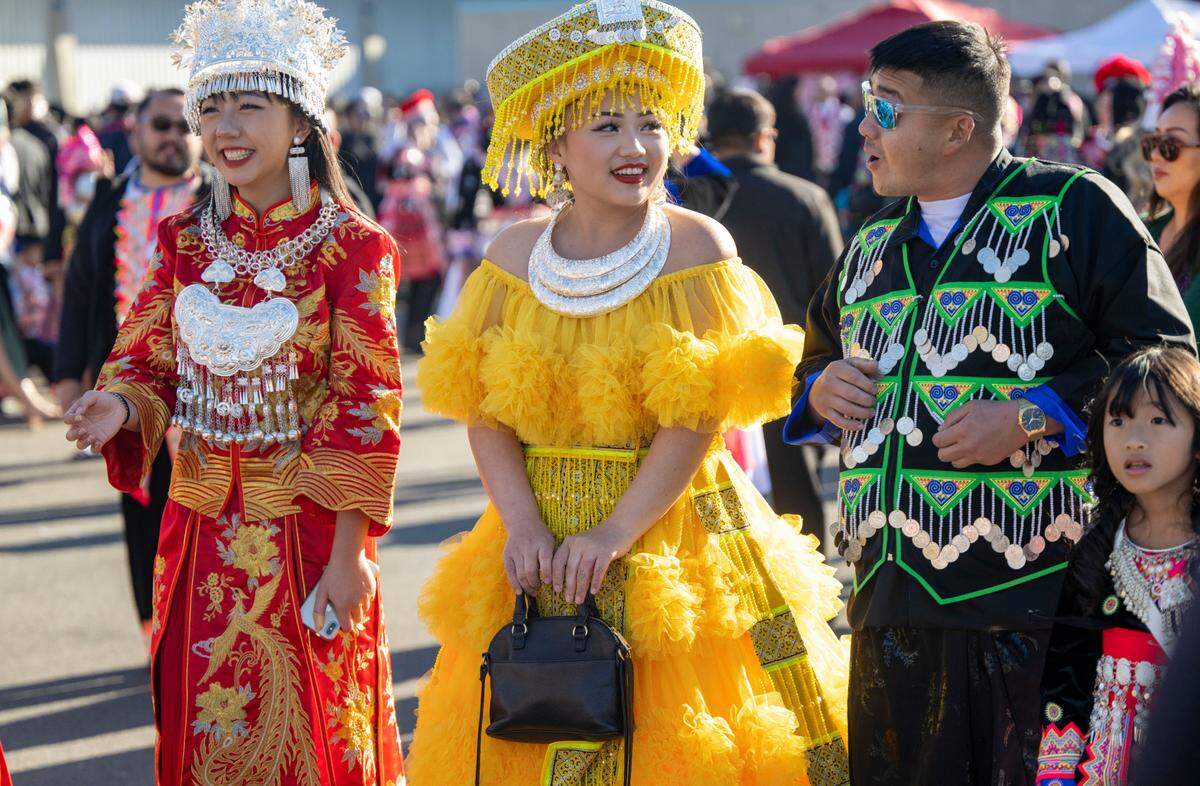 Allison Vang, left and her cousin See Vang, center, of Fresno, participate in the ball toss as Danny Xiong of Stockton comes up to talk to them during the Sacramento Hmong New Year festival Saturday.