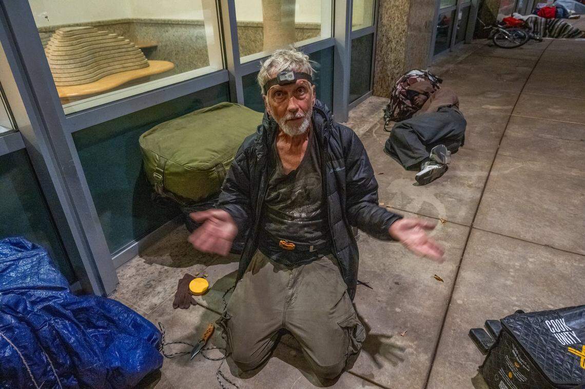 Randy Horn, 72, wears a camping light on his forehead as he prepares to sleep at Sacramento City Hall earlier this month. He said that during the rain, he appreciates being able to stay in the covered area, and he isn’t sure where he will go if the ordinance to ban sleeping there is passed.