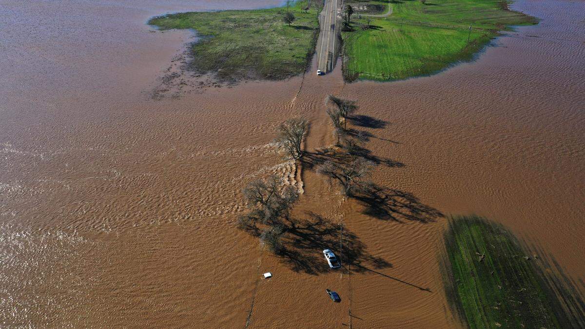 Three vehicles are submerged on Dillard Road west of Highway 99 in south Sacramento County on Sunday, Jan. 1, 2023, after heavy rains produced levee breaks in the area.