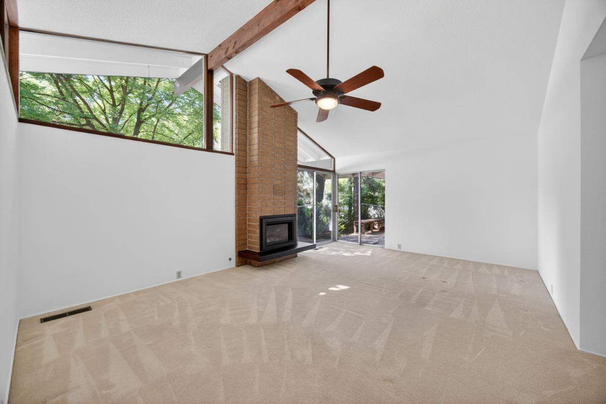 A stacked brick fireplace anchors the living space with classic midcentury texture and warmth.