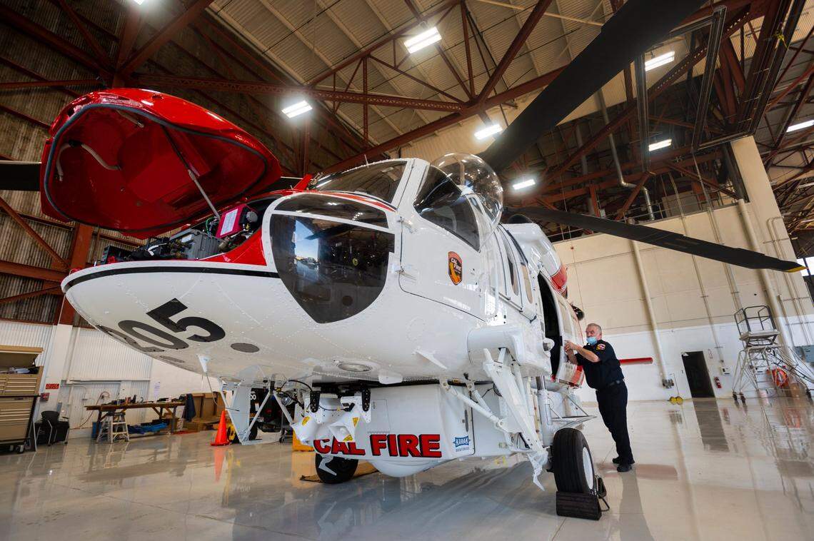 Cal Fire Senior Chief of Aviation Dennis Brown opens the door to the new Firehawk helicopter at the McClellan Airport in 2020. The Firehawk, a civilian version of the U.S. Army’s Blackhawk, has two engines, can hold up to 1,000 gallons of water, and has night flying capabilities.