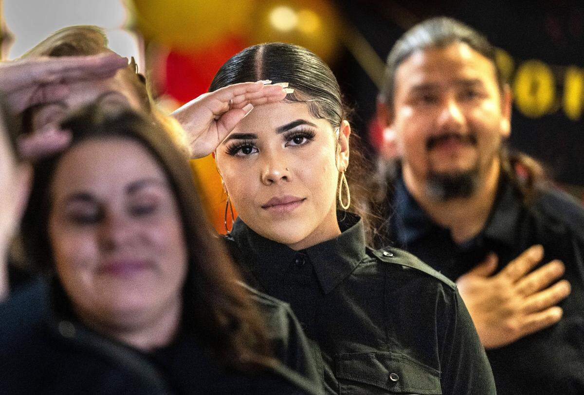 Britaney Gomez, 23, salutes the flag Tuesday during the graduation ceremony for her and four other women from a first-ever program to train female inmates to become firefighters. Gomez was convicted of killing two people in her hometown of Modesto while driving under the influence of marijuana when she was 16. She was one of five graduates participating in the event at St. John’s Lutheran Church in Sacramento.