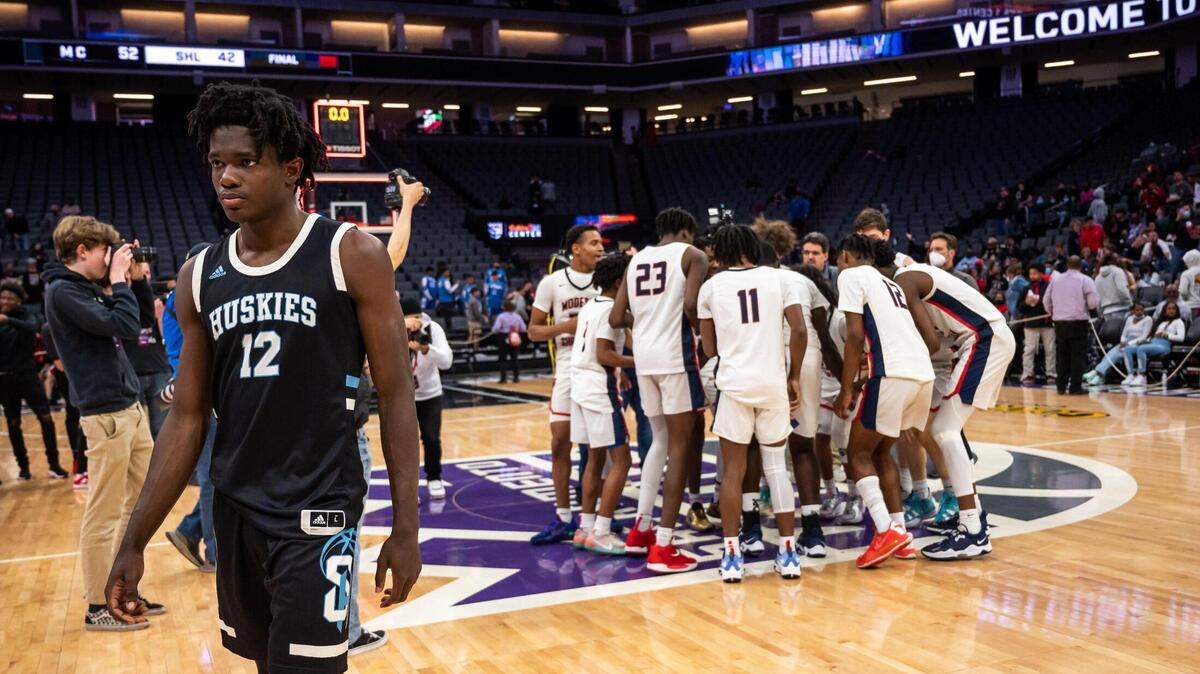 Sheldon Huskies’ Obinna Ibewiro (12) walks off the court as the Modesto Christian Crusaders rush the court after the buzzer ending the high school boys basketball Sac-Joaquin Section Division I championship game Saturday, Feb. 26, 2022, at Golden 1 Center in Sacramento. Modesto Christian beat Sheldon, 52-42, for the title.