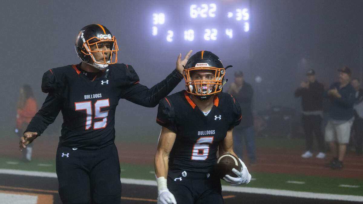 Vacaville’s tackle Caleb Noel (75), left, congratulates running back Darian Leon-Guerrero (6) after scoring the first go-ahead touchdown in the fourth quarter against Elk Grove during the high school football playoff game Friday, Nov. 12, 2021, in Vacaville. Elk Grove won 52-48 to advance.