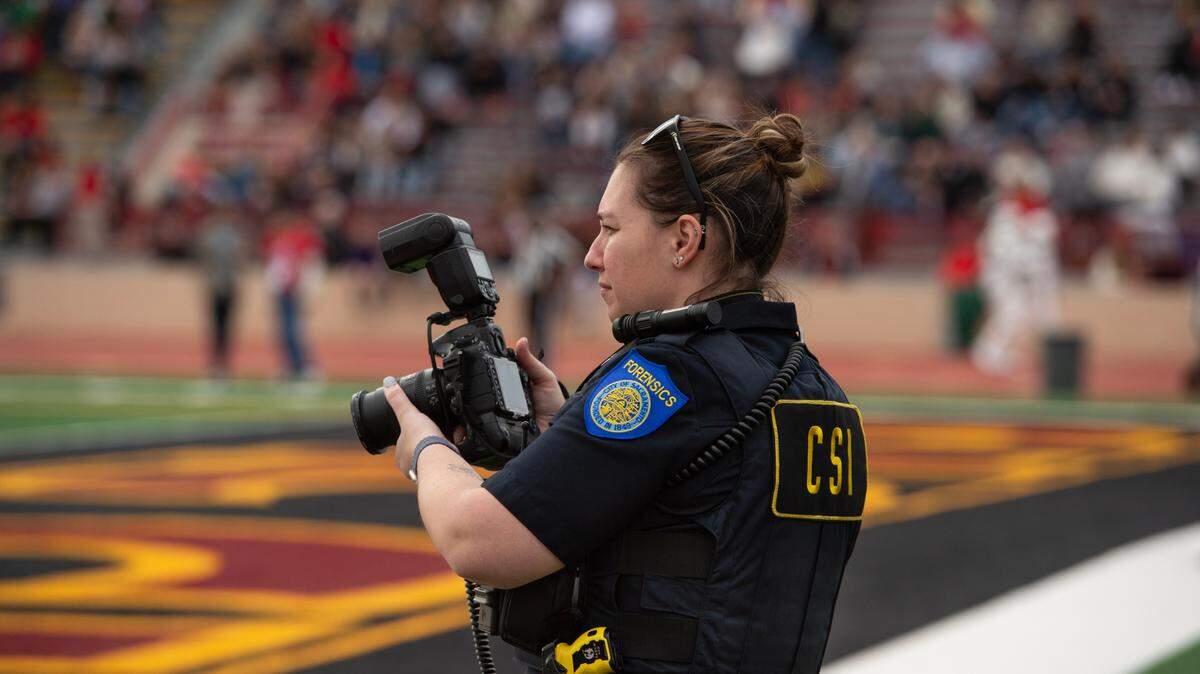 Katlyn Villarreal, a Sacramento Police Department CSI forensic investigator, photographs the 50th Pig Bowl football game on Saturday, Jan. 27, 2024, at Hughes Stadium. The 52nd edition of the law enforcement vs. firefighter charity tournament this coming Saturday will be played at Cal Expo for the first time.