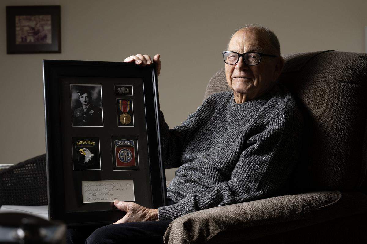 Howard Buford, 104, who fought in World War II during the Battle of the Bulge at Christmas in 1944, holds a display of memorabilia from his time in the Army last month in Sacramento. 