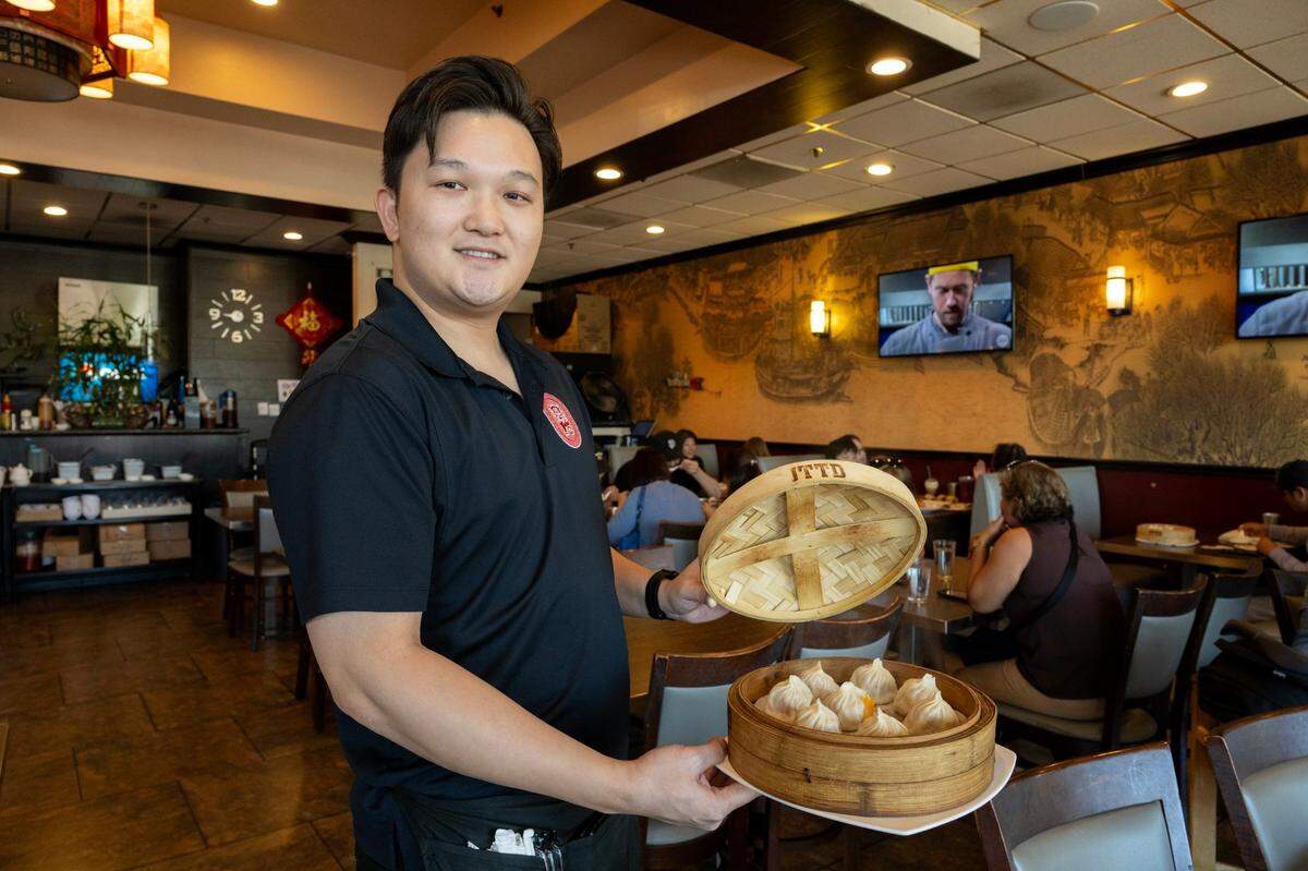 Manager Henry Kuang holds a serving of xiaolongbao soup dumplings filled with crab at Journey to the Dumpling on Oct. 15 in Elk Grove.