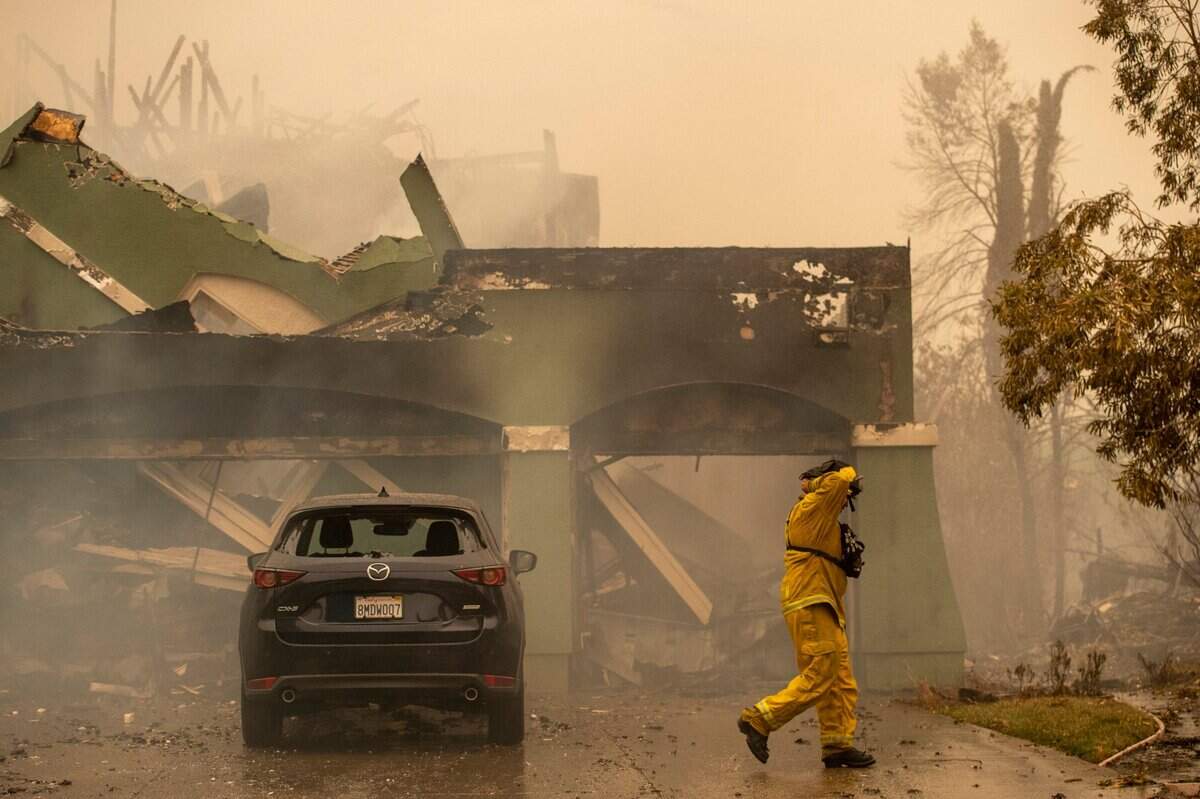 A firefighter from the South San Francisco Fire Department walks past a home burned by the Glass Fire on Mountain Hawk Road in Santa Rosa on Monday, Sept. 28, 2020.