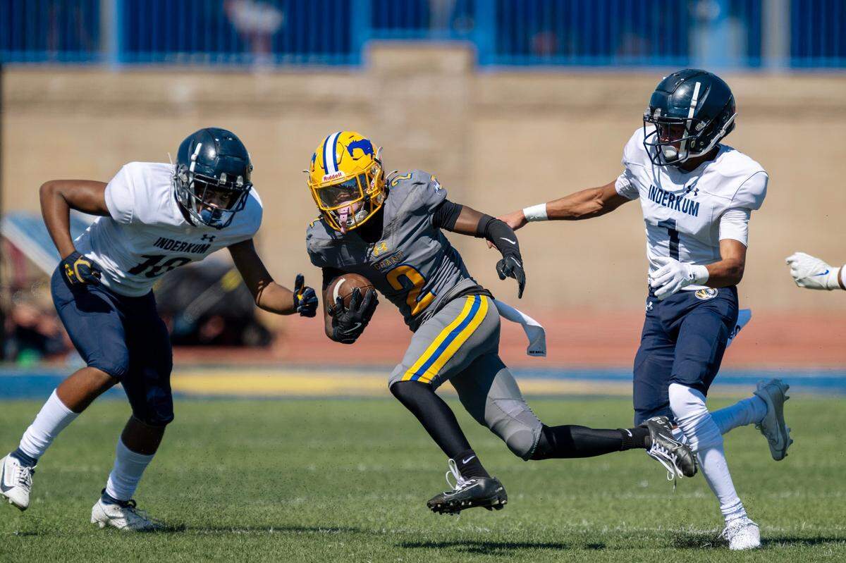 Grant running back Koby Shabazz (2) runs between two Inderkum Tigers defenders earlier this month.
