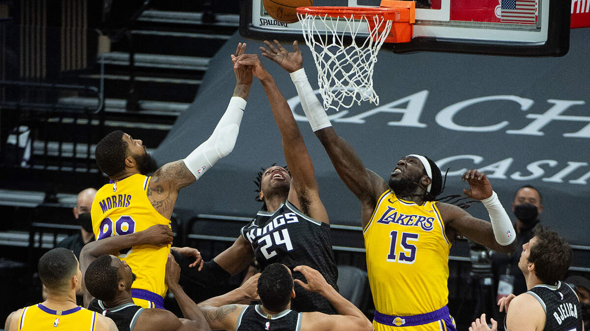 Sacramento Kings guard Buddy Hield (24) battles Los Angeles Lakers center Montrezl Harrell (15) and forward Markieff Morris (88) for a rebound with seconds left in the fourth quarter during a game at Golden 1 Center on Wednesday, March 3, 2021, in Sacramento. The Kings win 123-121.