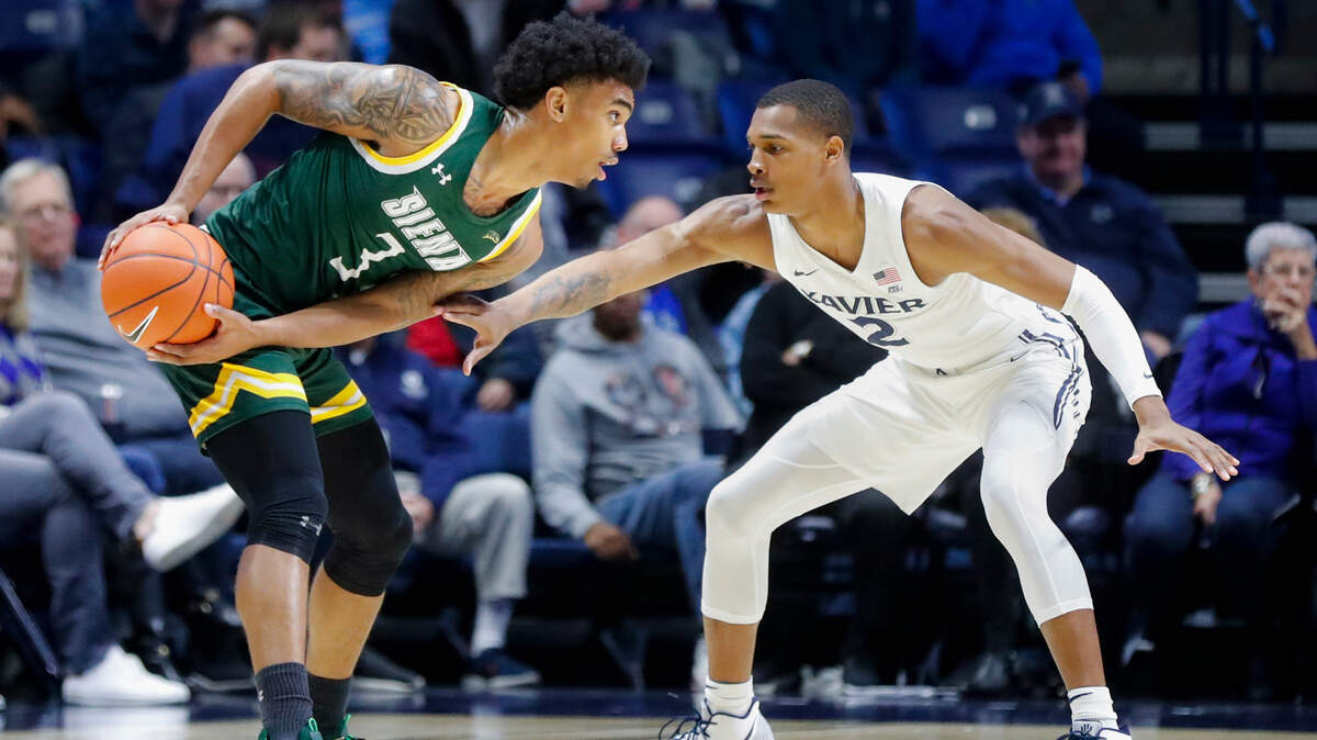 Xavier’s Dahmir Bishop (2) defends Siena’s Manny Camper (3) in the first half of an NCAA college basketball game, Friday, Nov. 8, 2019, in Cincinnati. (AP Photo/John Minchillo)