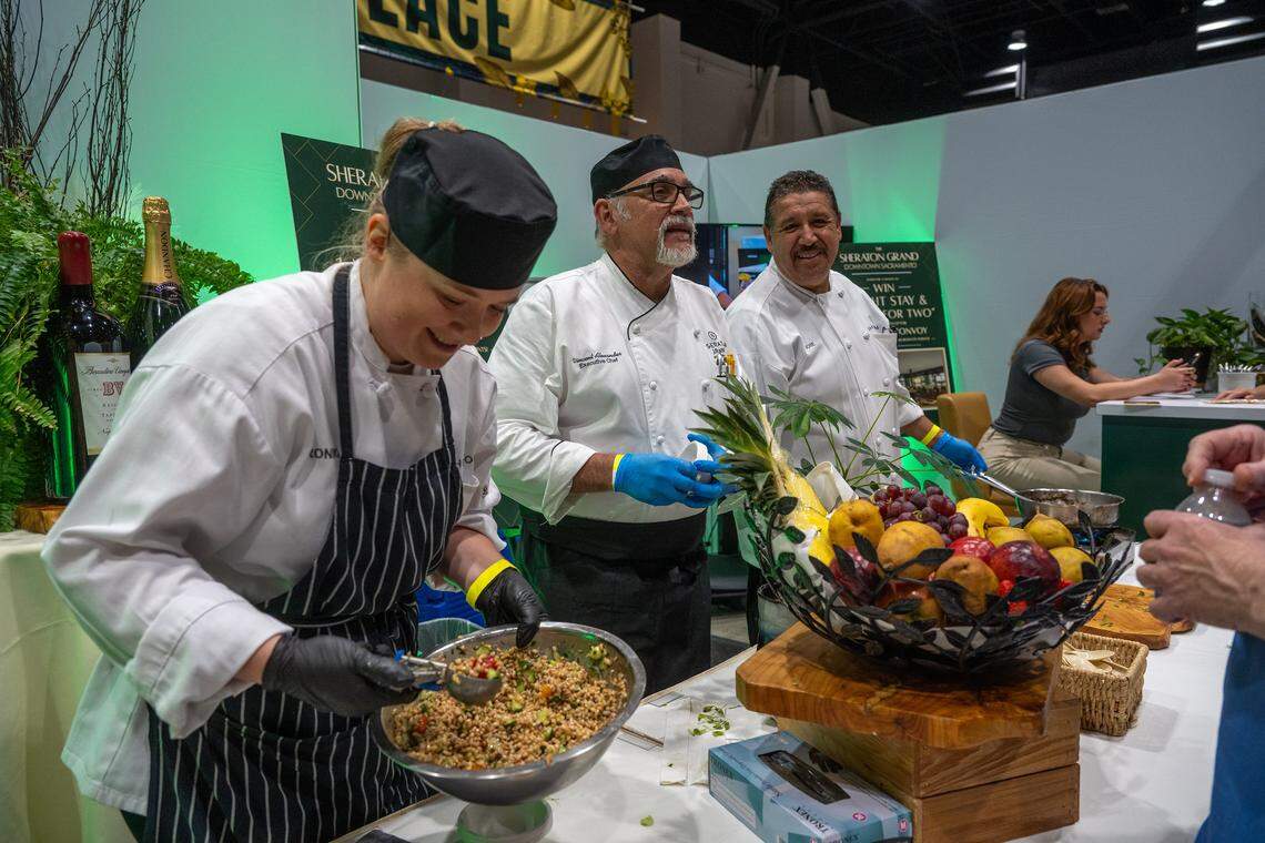 Vincent Alexander, center, executive chef at The Grand Sheraton Sacramento, chats with Terra Madre Americas festival-goers as sous chef Veronika Nestsiukovich, left, passes out farro salad and sous chef Jose Zaragoza, right, serves lamb navarin on Friday at the SAFE Credit Union Convention Center in Sacramento.