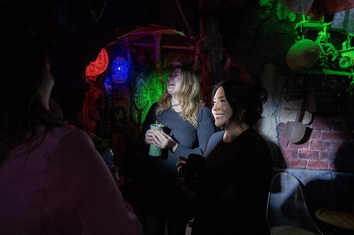 Caitlin Temple, left, and Crystal Vazquez enjoy the light show that accompanies their cocktail order at Hawthorne’s Hideout, a Tiki-themed underground speakeasy in Old Sacramento, on Thursday.