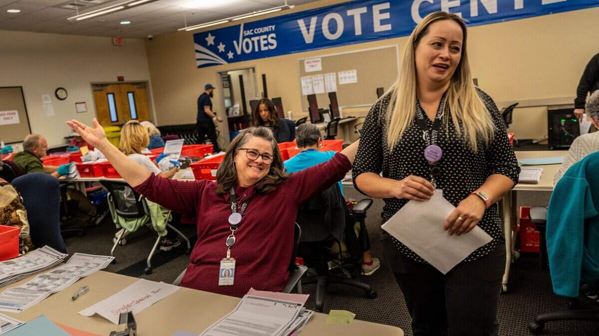 Election assistant Linda Hogge, left, expresses joy as she checks ballots inside the Voter Registration and Elections office in Sacramento on Nov. 3.