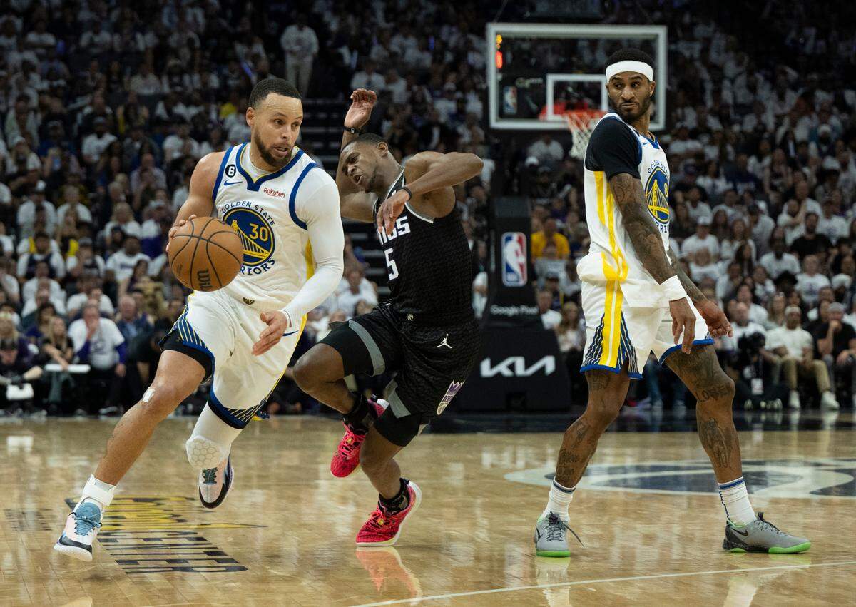 Golden State Warriors guard Stephen Curry (30) drives past Sacramento Kings guard De’Aaron Fox (5) during Game 1 of the first-round NBA playoff series at Golden 1 Center on Saturday, April 15, 2023.