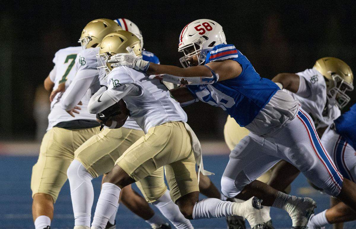 The Folsom Bulldogs’ Lua DaBerry (58) catches the Long Beach Poly Jackrabbits’ Benjamin Harris (6) in the backfield on Friday, Aug. 23, 2024.