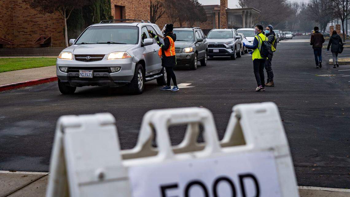 CalFresh outreach manager Lorena Carranza, along with volunteers, speaks with residents that are waiting in their cars at Hiram Johnson High School in 2021.