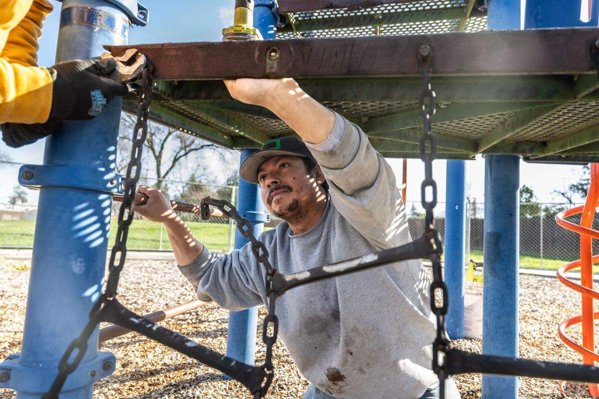 Jorge Lopez, with Sitewise Construction Inc., works to dismantle the play structure at Planehaven Park in North Highlands on Monday, Feb. 10. A new playground will be built at the site with federal funding secured by the park district.