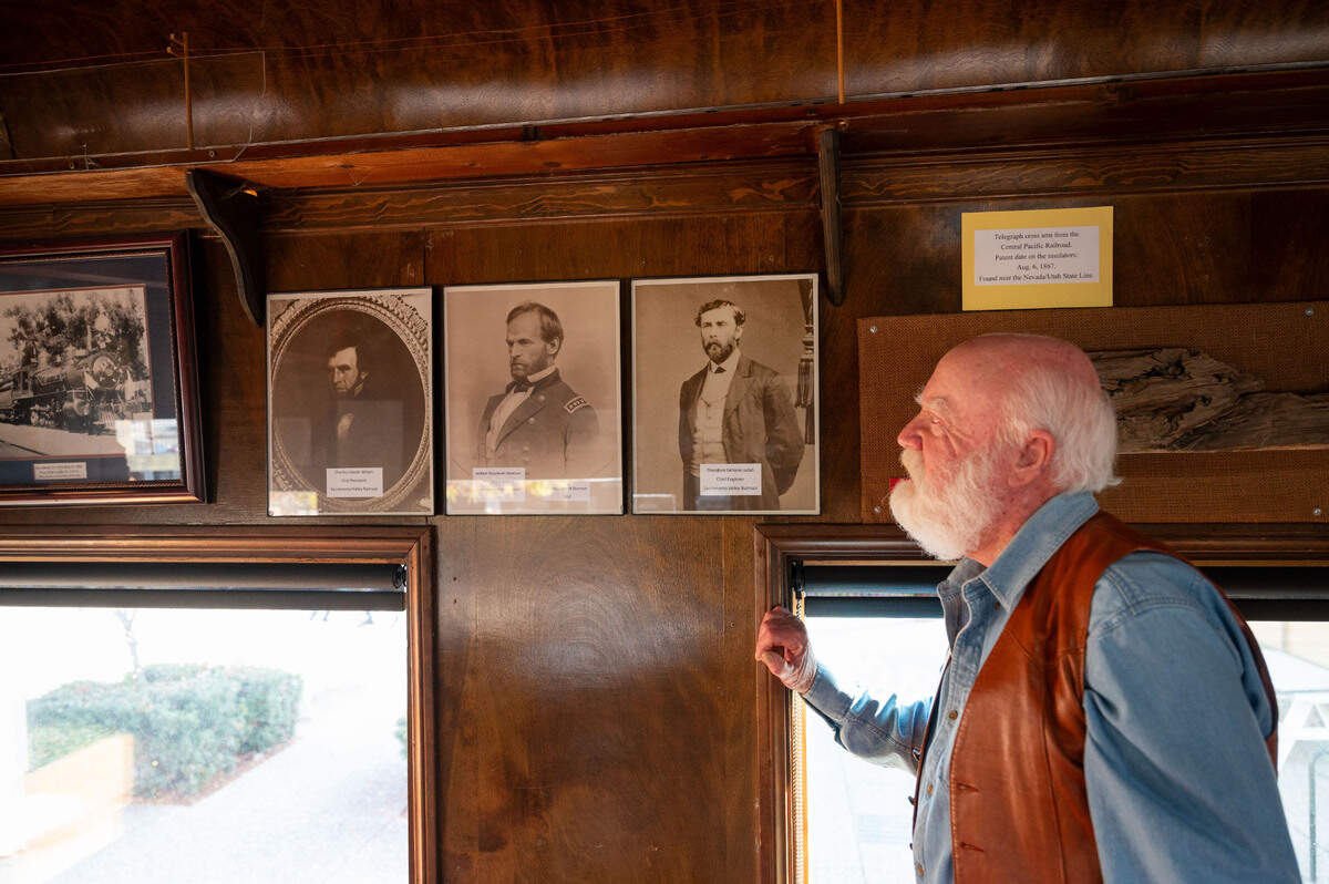 Resident historian Bill Anderson looks up at photos of the first leaders of the Sacramento Valley Railroad at Folsom’s Railroad Museum earlier this month.