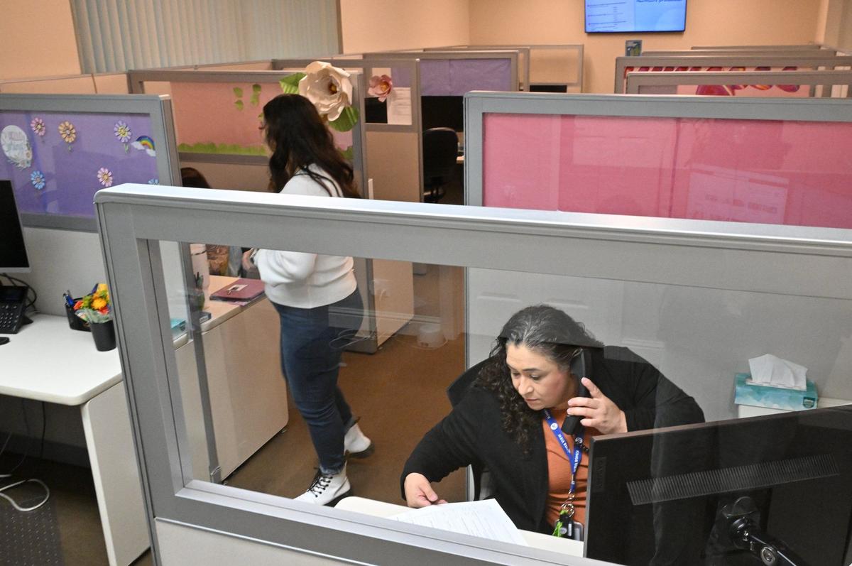 La especialista en prevención del suicidio Luz López, abajo a la derecha, responde a una llamada al centro de llamadas de la línea de salud mental 988, el viernes 26 de abril de 2024, en Fresno.
