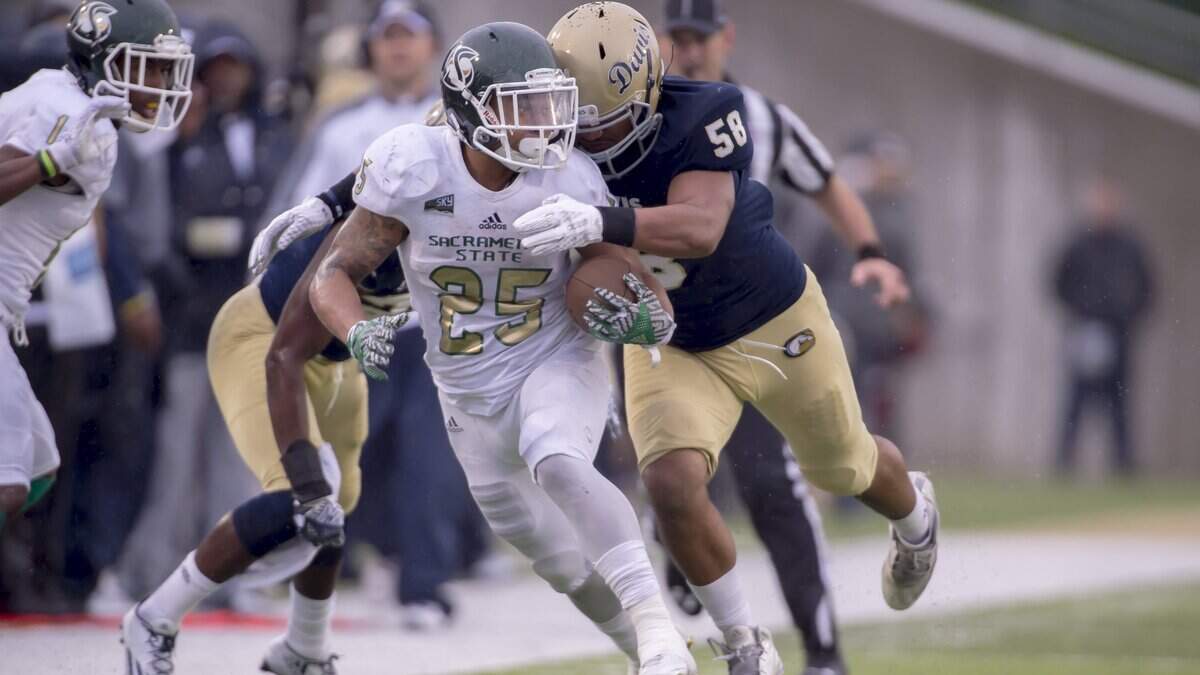 Sacramento State running back Jordan Robinson tries to evade a UC Davis defender during the Causeway Classic on Nov. 19, 2016, in Davis. Robinson is now with the Edmonton Eskimos in the CFL.