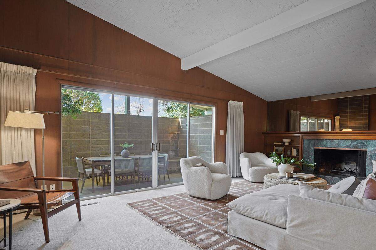 The living room has the original fireplace and vaulted ceilings.