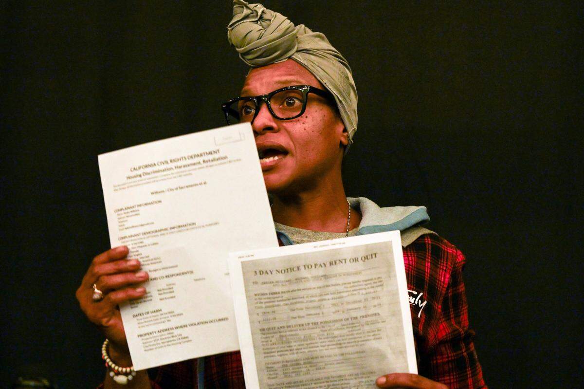 Tanika Williams holds paperwork asking her family to vacate her room at a Sacramento motel that serves a homeless shelter during a press conference on Wednesday. Williams appeared with her daughter Makhila, 2, who has sickle cell anemia.