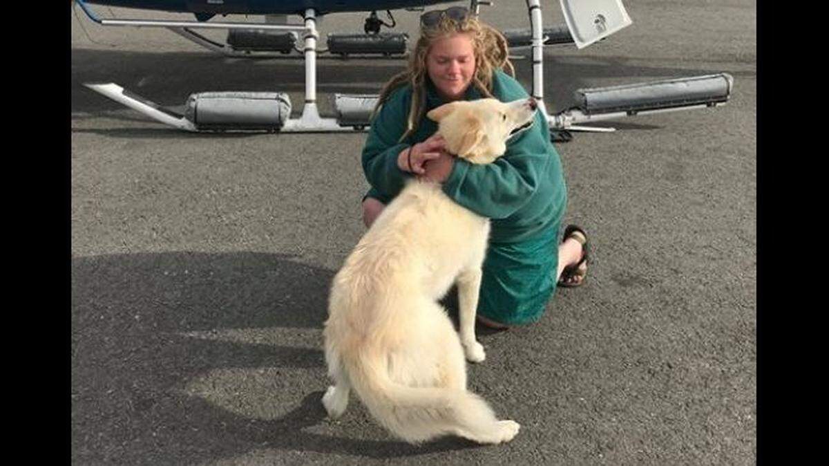 Amelia Milling, 21, hugs Nanook, a husky who she says helped save her after a fall down a mountain and a later plunge into an icy river in Alaska.